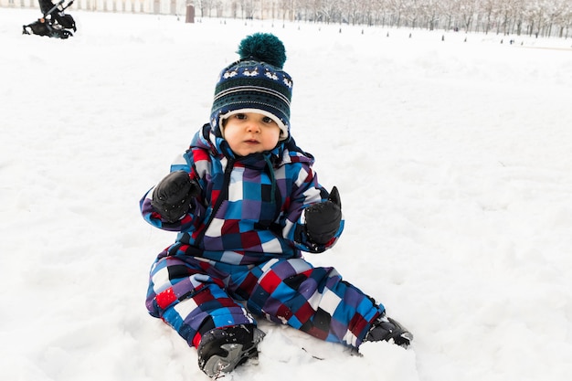 Bambino sulla neve nella foresta