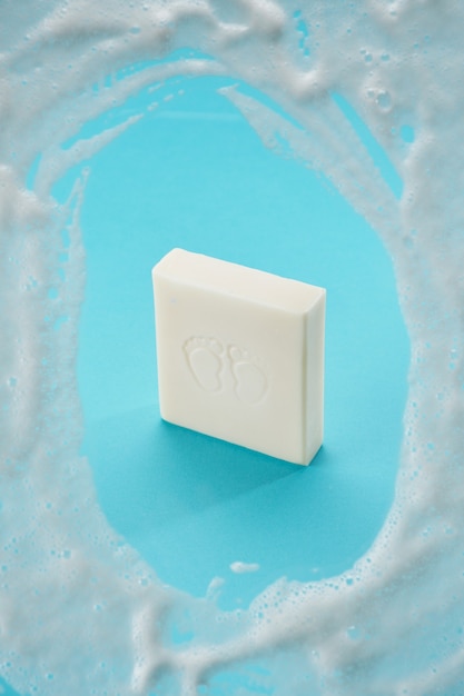 baby soap of white color on a blue background with soap foam