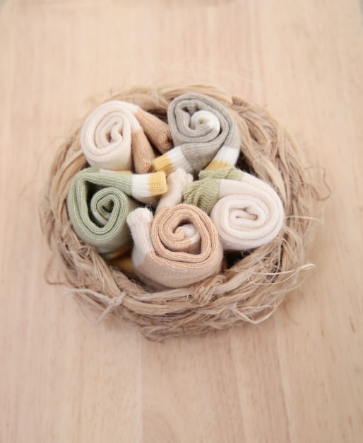 Baby socks hanging on the clothesline on wooden background