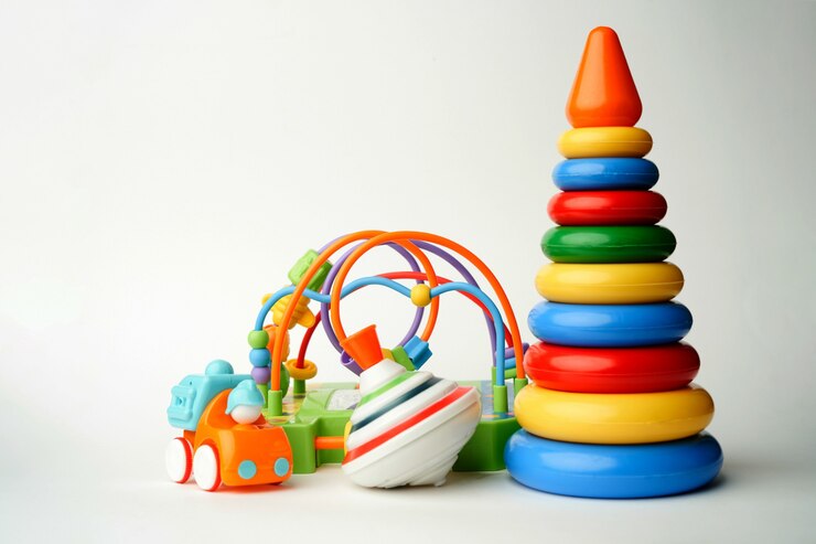 Baby speelgoed collectie op wit oppervlak met kopie ruimte. Plastic piramidespeelgoed met zweefmolen en auto.
