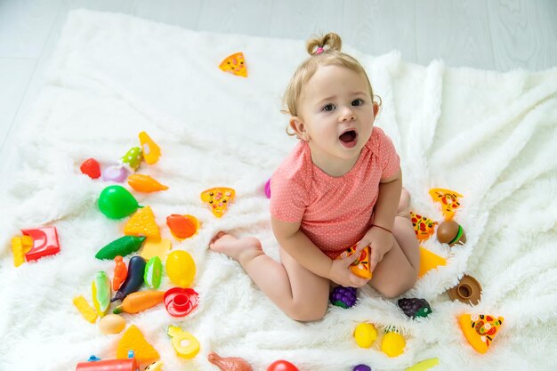 Baby speelt met speelgoed in haar kamer Selectieve aandacht Kind