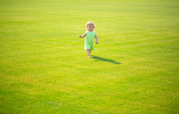 Baby spelen in groen gras ontwikkeling van kinderen schattig klein kind dat in een herfstveld loopt