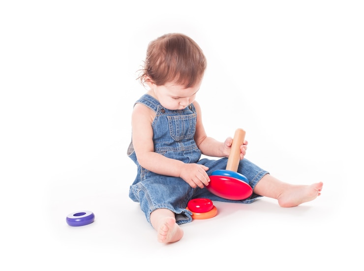 Foto baby spelen met houten piramide geïsoleerd op wit