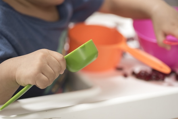 Baby spelen met plastic lepel