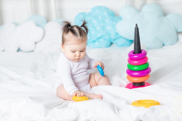 Baby spelen op het bed van de huispiramide, het concept van een gelukkig liefdevol gezin en de ontwikkeling van kinderen