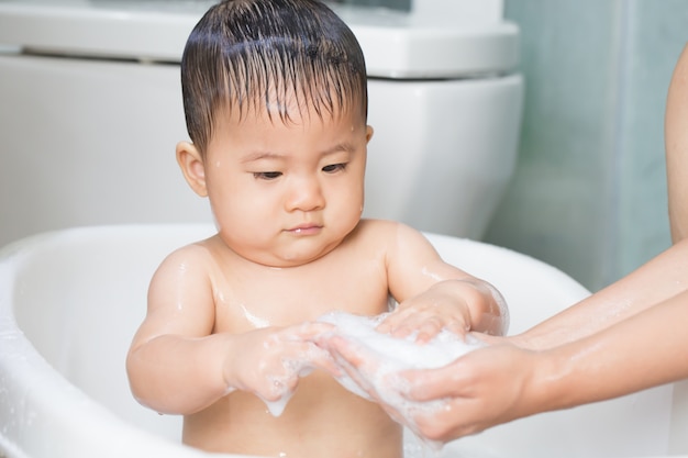 Baby spelen zeepbellen tijdens het bad