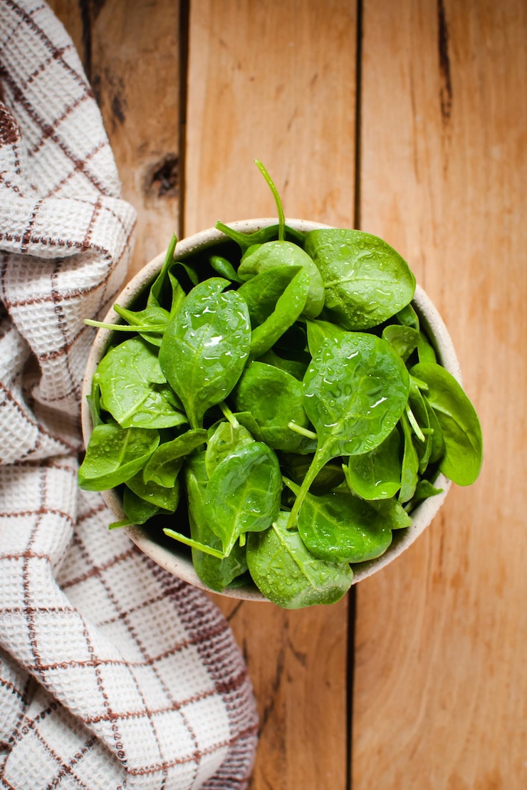 Photo baby spinach in a bowl on wooden table top view