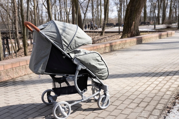 Baby stroller with baby in the park outdoors.