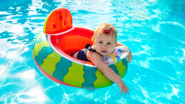 Baby swims in a circle in the pool. Selective focus.