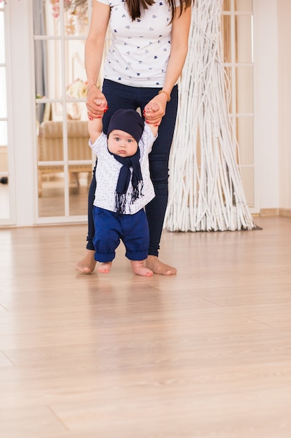 Baby taking first steps with mother help,