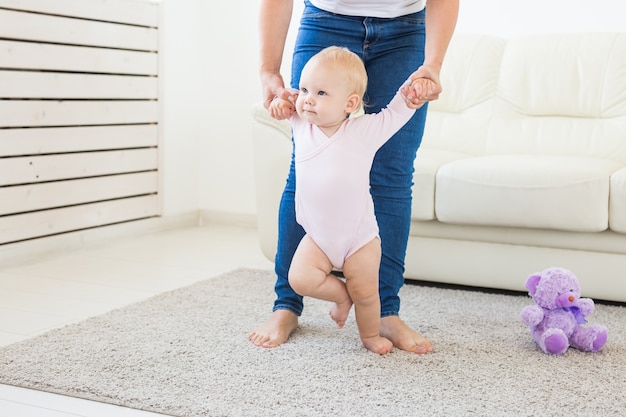 Baby taking first steps with mother's help at home