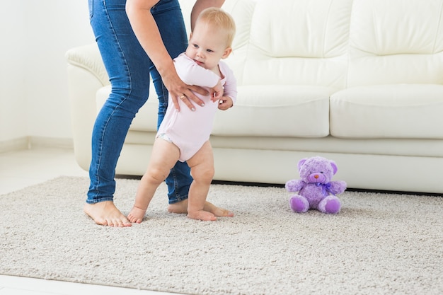 Baby taking first steps with mother's help at home