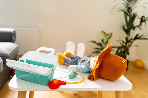 Baby toddler girl playing with doctor's kit and doll toys