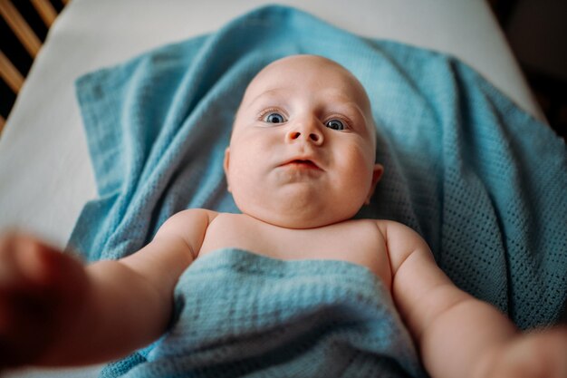 Baby toddler taking a selfie in crib holding smartphone scared face