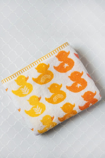 Baby towel with cute ducks on gray background.