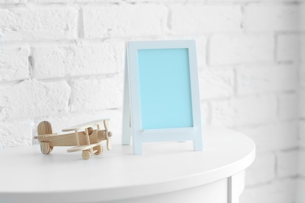 Baby toy and frame on brick wall background