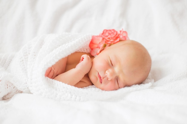 Baby tugged in white blanket