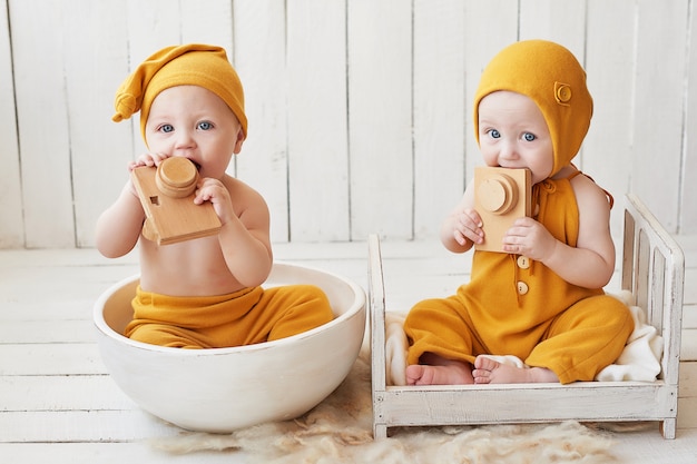 baby tweeling in oranje pakken poseren