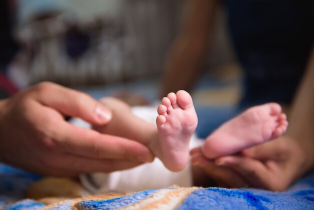 Baby voeten in handen van de ouders. Pasgeboren babyvoeten