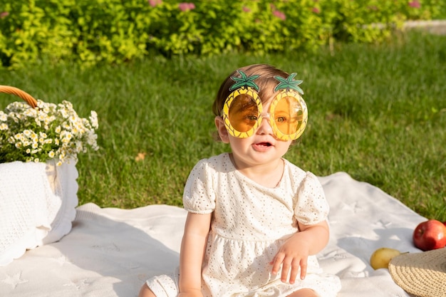 Photo baby wearing goggles and wearing sunglasses on a blanket