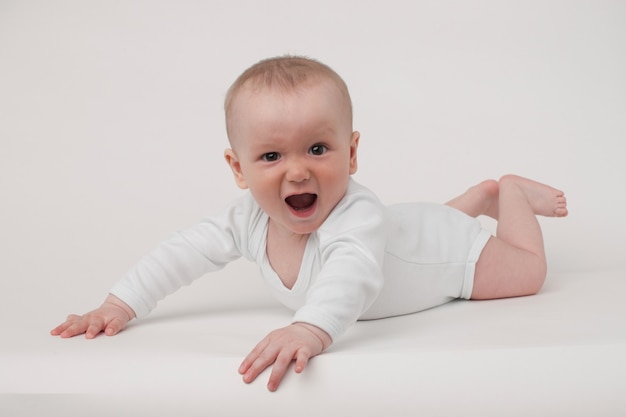 Baby on a white background in a white pajamas