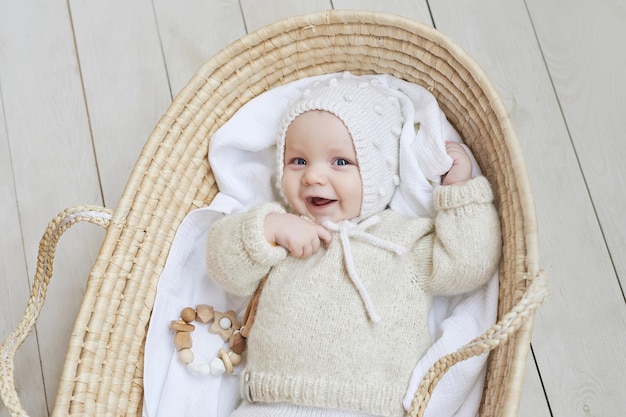 Photo baby in wicker cradle with wooden toy mothers day children protection day cheerful child happy childhood