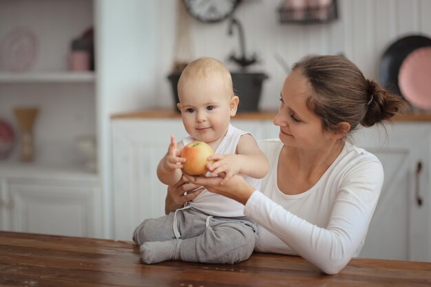 Photo baby with an apple an concept of a healthy childhood moms love