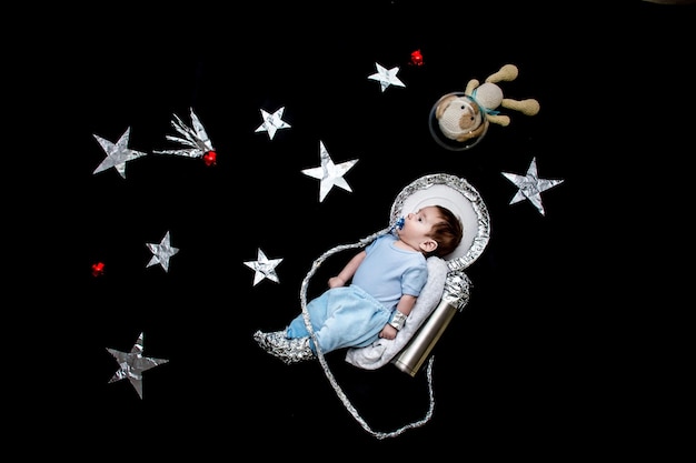 Baby with astronaut costume against black background