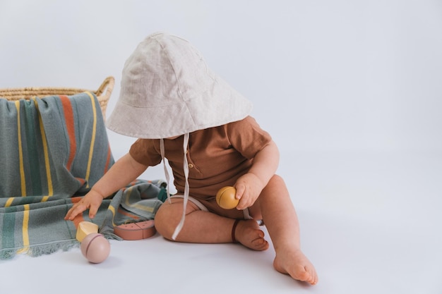 Bambino con look da spiaggia su sfondo bianco giocando