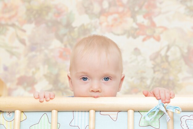 a baby with blue eyes in a crib