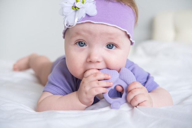 A baby with blue eyes wearing a purple headband.