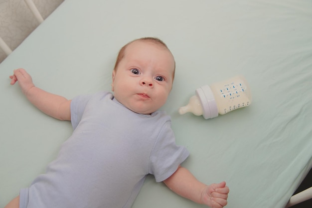 Bambino con una bottiglia nella culla vista dall'alto copyspace per alimenti per bambini alimenti per bambini bambino affamato