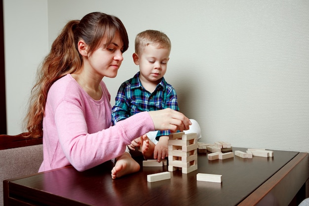 Baby with mom playing in wooden blocks