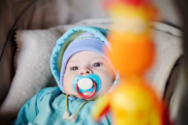 Baby with a pacifier in his mouth is in a wheelchair