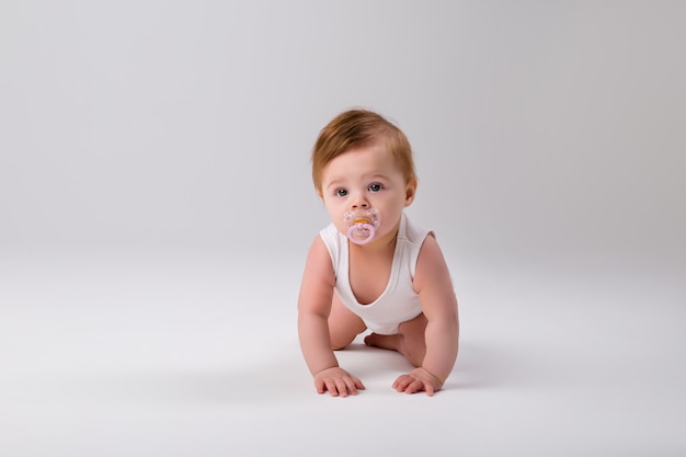 Baby with a pacifier in his mouth on a white background