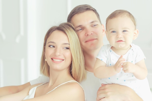 baby with parents in a cozy house / healthy young family mom dad and baby, happiness smile