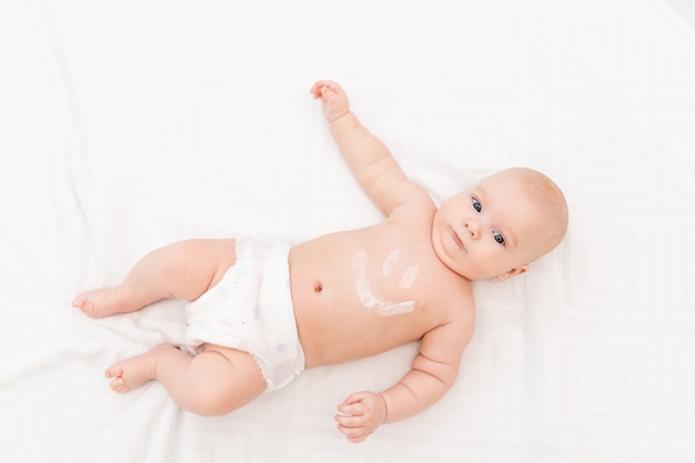 baby with a smile on his stomach on a light background