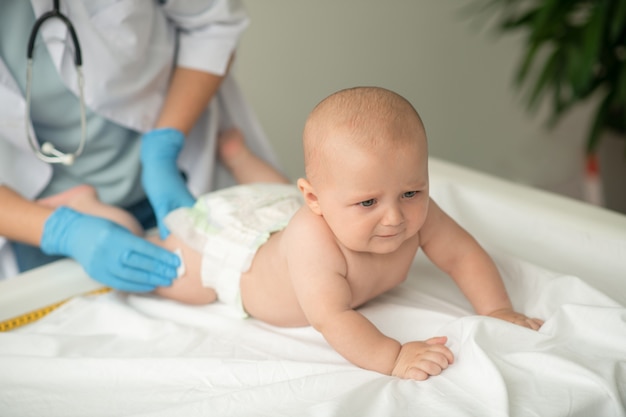 Baby wordt voorbereid op een injectie in de dij