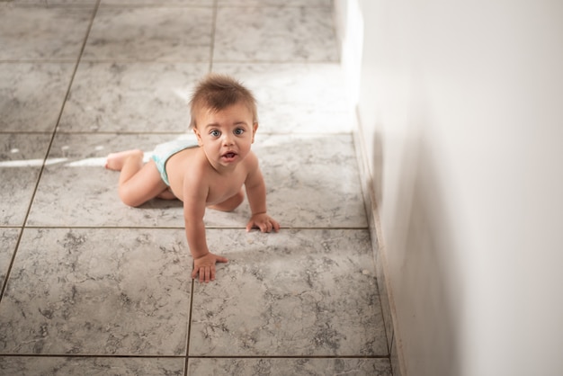 Baby zittend op de vloer thuis