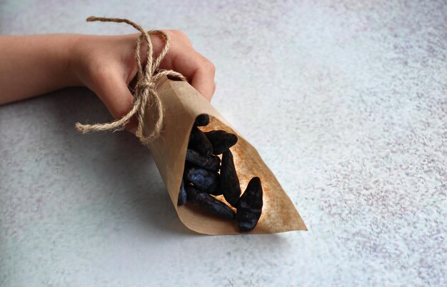 Baby39s hands with paper bag with honeysuckle berry