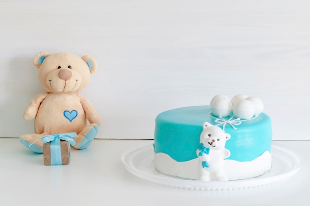 Babyblauwe heerlijke cake versierd met geschenkdoos en teddybeer voor de eerste verjaardag van het kind. set met blauwe kleuren decoraties voor baby shower party voor jongen.
