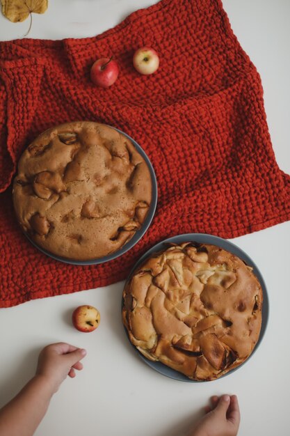 Babyhanden reiken naar de appeltaart op wit tafelblad ontbijt met zelfgemaakte appeltaart Charlotte