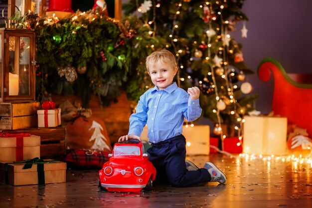 Babyjongen blonde jongen naast de kerstboom