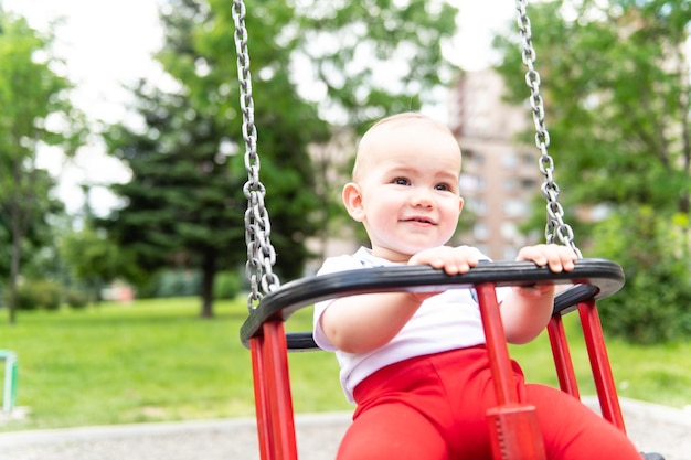 Babyjongen die plezier heeft op een schommel