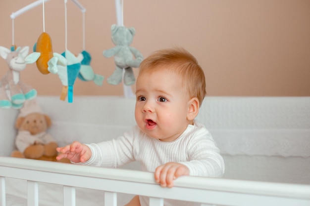 Babyjongen in de wieg in de kinderkamer