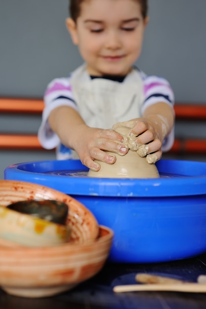 Babyjongen in een aardewerkworkshop