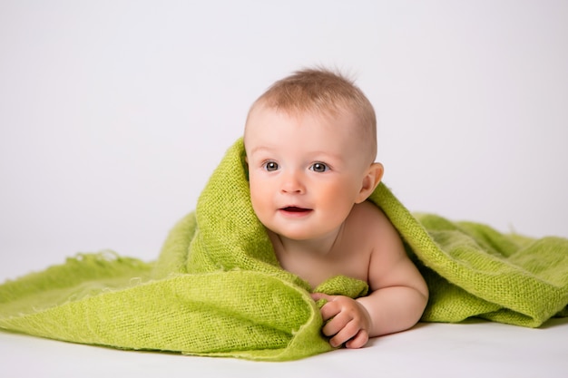 babyjongen in groene plaid op wit