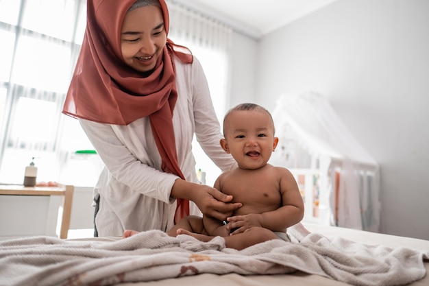 Babyjongen met moeder na het nemen van een bad