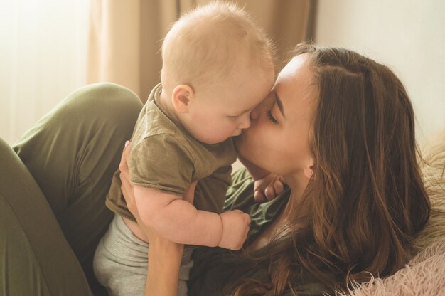 Babyjongen met moeder op het bed