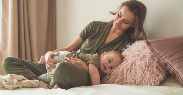 Babyjongen met moeder op het bed